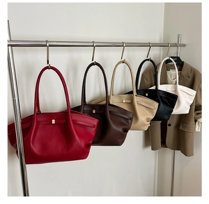Detailed view of assorted colors for the large leather tote bag hanging on a metal rack