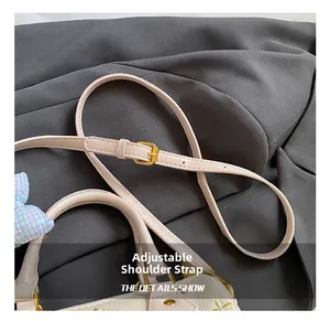 Detail of adjustable pink strap with gold buckle on floral lychee leather pillow bag