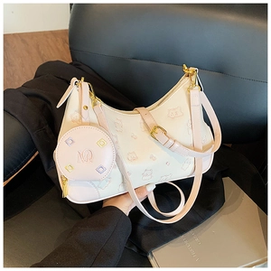 Detail of cream dumpling bag with pink trim, embossed cat pattern and coin purse