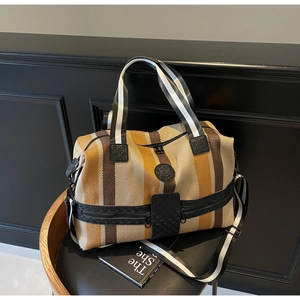 Macro view of striped canvas travel bag with leather accents and durable woven handles