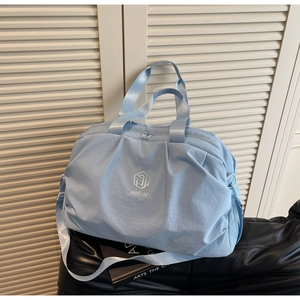 Light blue travel bag with adjustable shoulder strap and side mesh pocket shown on display