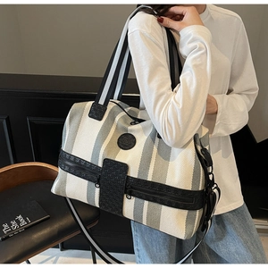 Detail of grey striped canvas travel bag showing large capacity and zipper pockets