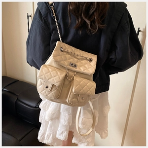 Rear view of cream quilted backpack with chain straps on model wearing lace skirt
