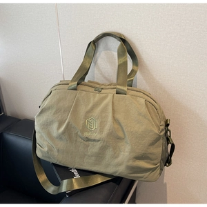 Detail of olive green waterproof gym bag featuring pleated design and nylon texture