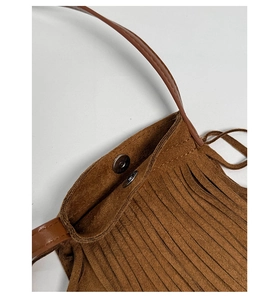 Détail du sac bandoulière à franges caramel montrant le fermoir magnétique et le daim