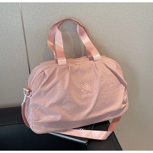 Pink travel bag with durable handles, brand logo, and mesh side pocket for water bottles