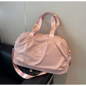 Pink waterproof travel bag detail showing NINGJIA logo and nylon fabric texture on chair