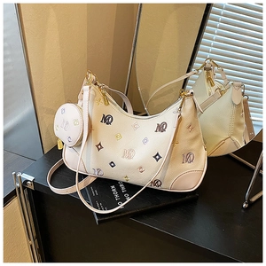Detail of cream leather hobo bag featuring MQ embroidery and matching round coin purse