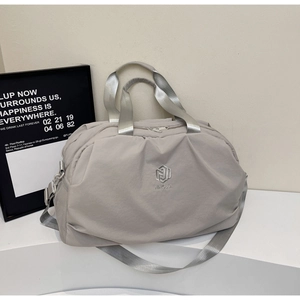 Detail of grey travel bag with NINGJIA embroidery and textured nylon fabric surface