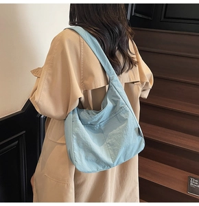 Detailed view of light blue large hobo shoulder bag with draped pleated fabric texture