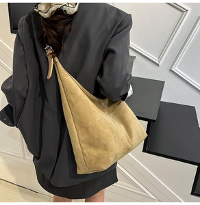 Detail of a large suede tote bag in warm camel yellow with an adjustable wide strap