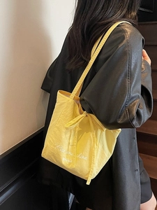 Yellow fabric tote bag with Rise and Shine print and bow detail worn by a model