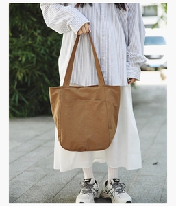 Outdoor lifestyle shot of a large brown tote bag with high-capacity shoulder design