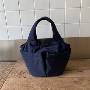 Détail d'un sac cabas en nylon bleu marine à plusieurs poches avec poignées épaisses