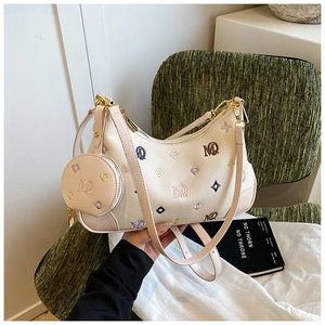 Detail of beige crescent shoulder bag with MQ embroidery and mini coin purse charm