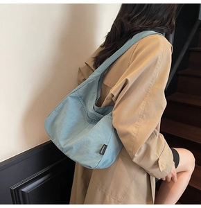 Close-up of a large light blue canvas tote bag showing soft nylon fabric and logo detail