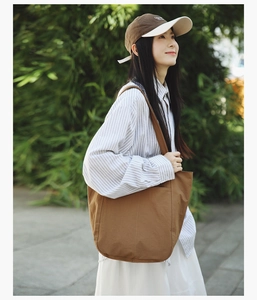 Outdoor shot of a brown canvas tote bag with large front pocket in minimalist style