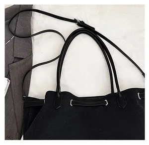 Detail of minimalist black tote bag with slender leather straps and chic texture