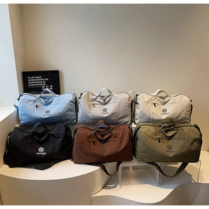 Group display of waterproof travel bags in multiple colors with handles and shoulder straps