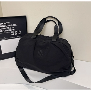 Detail of waterproof nylon travel bag with brand logo on a white geometric stand