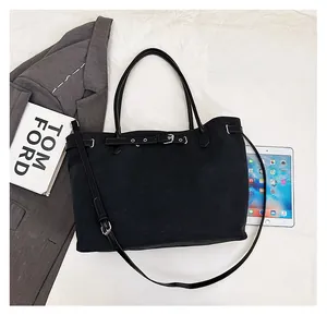 Detail view of large capacity tote bag next to a tablet and book showing real-life size