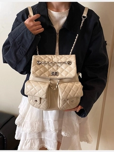 Quilted beige backpack with chain straps and silver twist locks in vintage elegant style