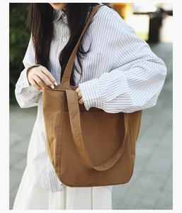 Detailed view of brown large-capacity tote bag with side pockets and soft handles