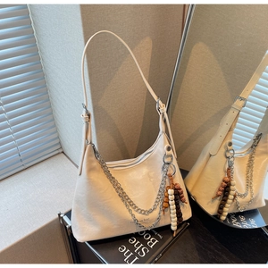 Detail of cream white PU leather bag with silver chain and colorful beaded pendant