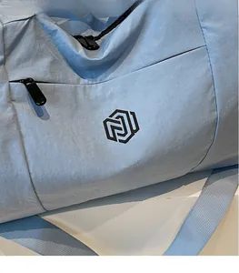 Close-up of light blue travel bag featuring durable nylon fabric and branded logo detail
