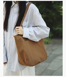 Detailed texture of brown casual tote bag with reinforced stitching in outdoor light