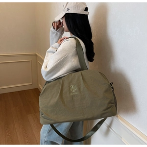 Olive green travel bag detail showing large capacity, water-resistant fabric and logo