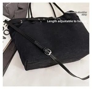 Detail of adjustable black leather strap with silver buckle on canvas tote bag
