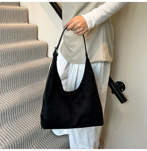 Detailed view of black suede hobo bag featuring silver buckle and adjustable strap