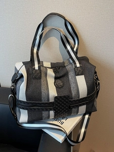 Large black and white striped travel tote bag with leather trim and shoulder strap