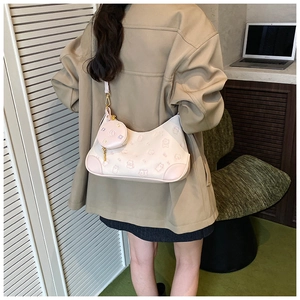 Pale pink hobo bag with embossed bear pattern and mini round pouch shown on model