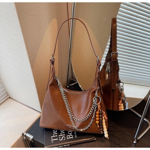 Detail of brown PU leather bag with silver chains, wood beads and New York lettering