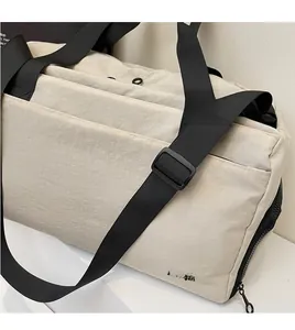Detailed close-up of beige travel bag showing black nylon handles and NING JIA logo