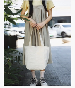 Outdoor shot of a large white tote bag with a unique textured paper-like finish