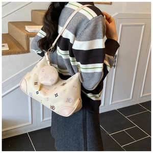 Detail of beige hobo bag featuring colorful letter M embroidery and round mini coin purse