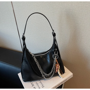 Detail view of black matte leather hobo bag with silver chain and colorful beaded tassels