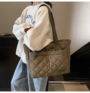 Detail view of army green quilted tote bag showing diamond stitching and side pocket