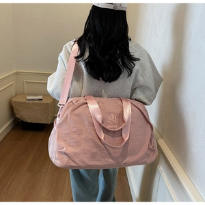 Pink large capacity travel bag with waterproof nylon fabric shown on model's back