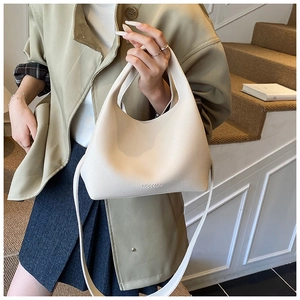 Close-up of beige lychee grain leather bucket bag with HOGOMU logo and long strap