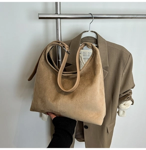 Detail view of khaki suede tote bag with central vertical stitching and adjustable strap