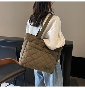Detailed close-up of olive green quilted puffer tote bag with diamond stitching texture