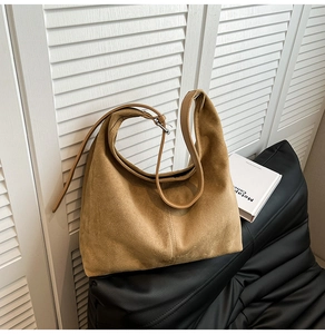 Close-up of camel suede hobo bag with adjustable leather strap and silver buckle