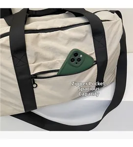 Detail view of the side zipper pocket on a minimalist travel bag showing phone storage