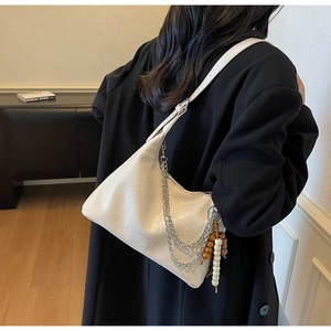 Detail of cream underarm bag with silver chains and fashion bag NEW YORK text print