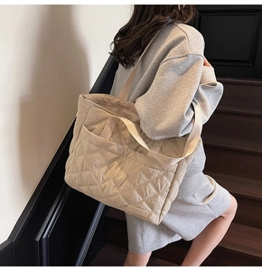 Close-up of quilted nylon tote bag featuring diamond pattern and brand label on front