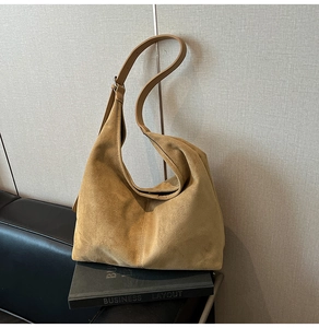 Detail of the soft camel suede texture and durable leather strap of this large hobo bag